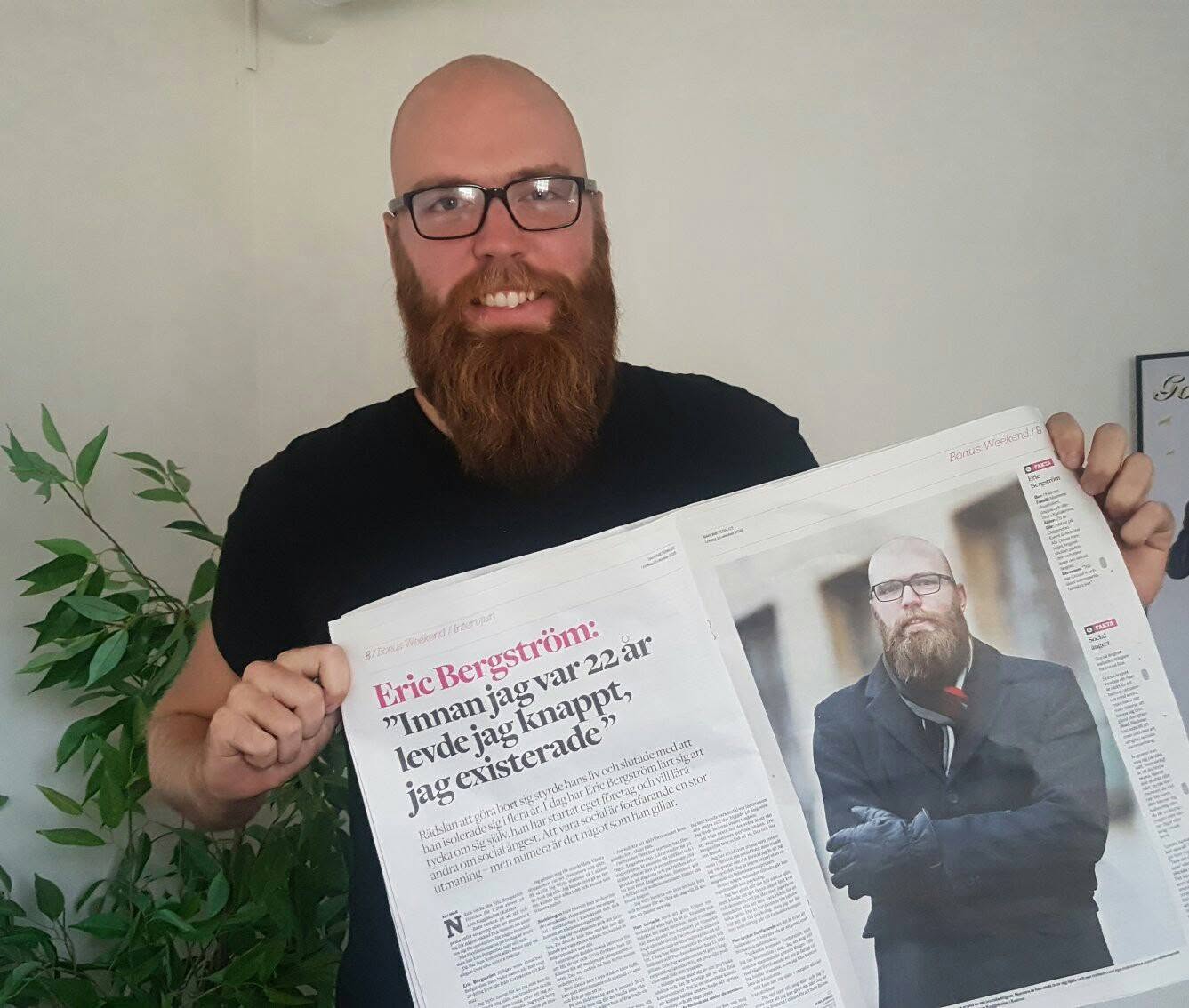 Eric Bergström håller upp en tidningsintervju med rubriken Innan jag var 22 år levde jag knappt