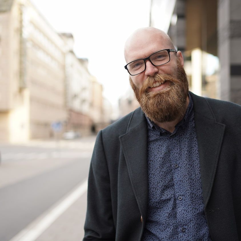 Eric Bergström ler mot kameran på en gata i Stockholm